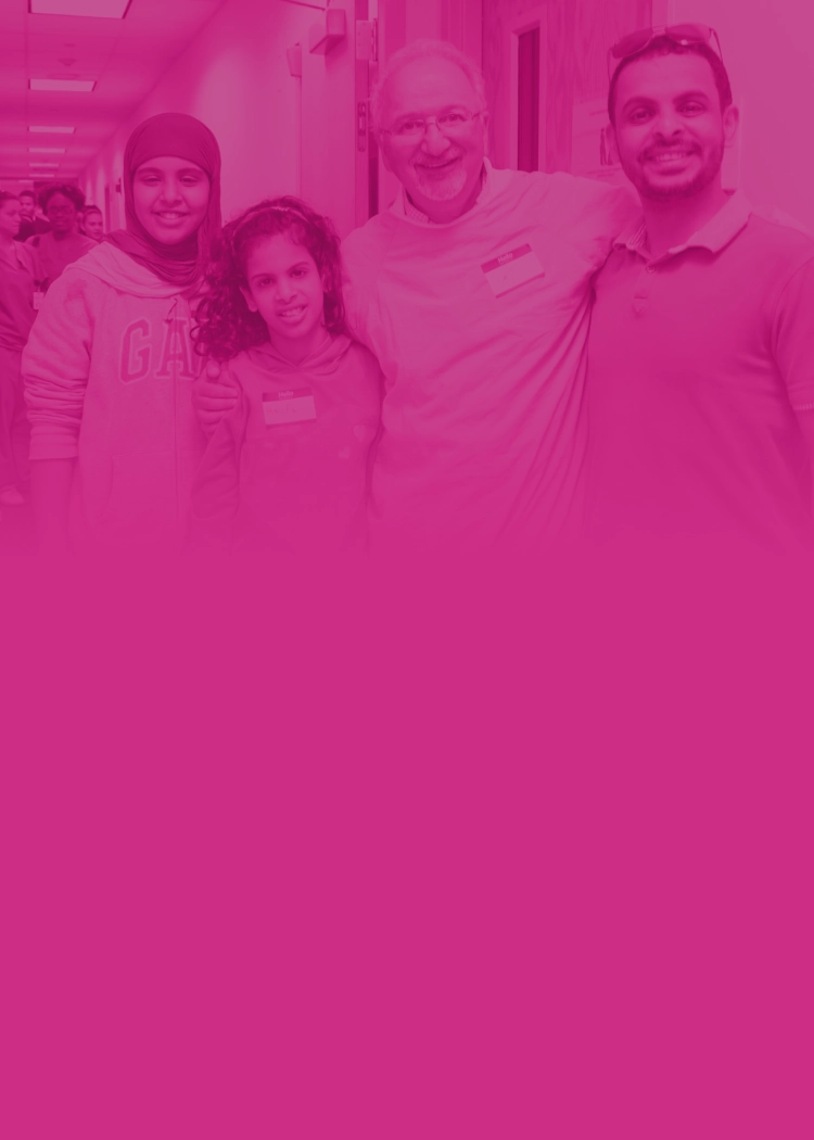 A provider and family arm-in-arm and smiling in a dentist office.